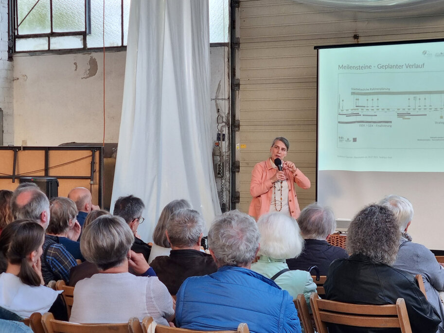 Bei der Abschlusspräsentation in Münnerstadt erklärt eine Frau die Ergebnisse des Beteiligugsprozesses für das Treibhaus-Projekt.